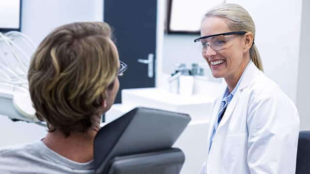 Female dentist interacting with male patient